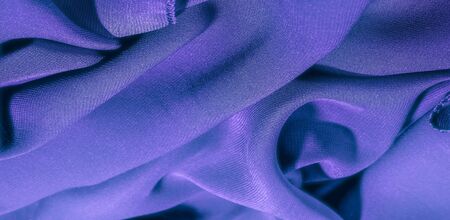 Background texture of silk fabric. This is a natural purple blue scarf, this beautiful nylon satin made of rayon with a transparent hand and a wonderful sheen is perfect for your projects.の写真素材