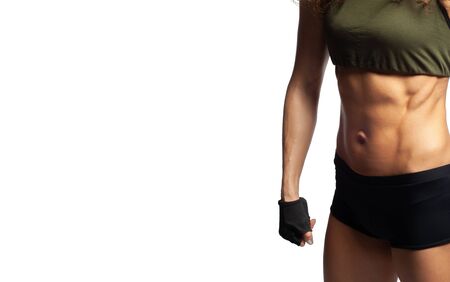 Studio photo of a model on a white background, Fitness healthy lifestyle, Beautiful tummy, embossed abdominal muscles, quickly pump up the abdominal press to a girl at homeの写真素材