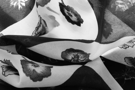 Silk fabric. Black and white squares with floral print. The flowers are black and white. Texture...