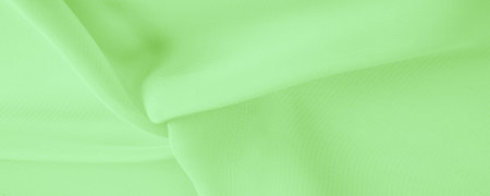 Texture. template. Pale green silk polyester. Background from color lime green silk fabric. Textured background made of transparent and light fabric for sewing clothes. Textile panoramaの写真素材