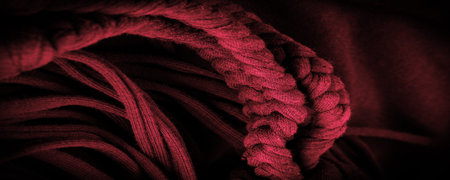 Texture, background, pattern. Fabric in red braids. Knitted knitted background with embossed pattern. Braids in knitting.の写真素材