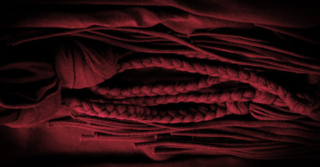 Texture, background, pattern. Fabric in red braids. Knitted knitted background with embossed pattern. Braids in knitting.の写真素材