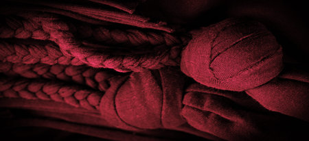 Texture, background, pattern. Fabric in red braids. Knitted knitted background with embossed...