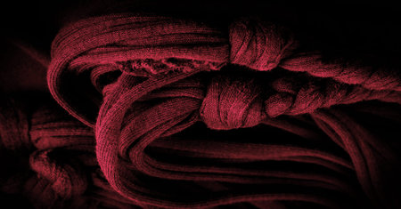 Texture, background, pattern. Fabric in red braids. Knitted knitted background with embossed...