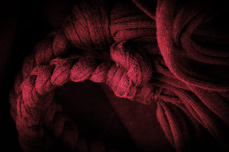 Texture, background, pattern. Fabric in red braids. Knitted knitted background with embossed...