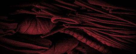 Texture, background, pattern. Fabric in red braids. Knitted knitted background with embossed...