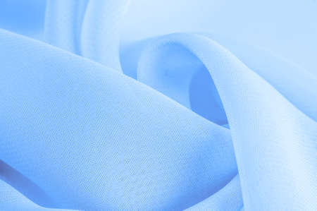 Texture. template. Light blue silk polyester. Background from aqua color silk fabric. Textured background made of transparent and light fabric for sewing clothes. Textile panoramaの写真素材