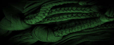 Texture, background, pattern. Fabric in green braids. Knitted knitted background with embossed pattern. Braids in knitting.の写真素材