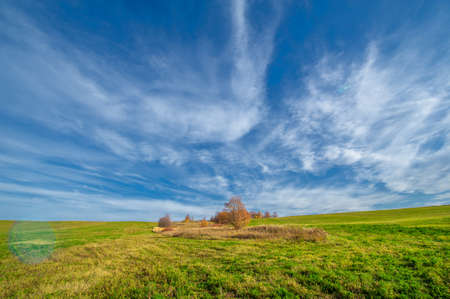 Autumn landscape photography, the European part of the Earth. Rural landscape with a beautiful gradient of the evening sky at sunset. Green field and village on the horizonの写真素材