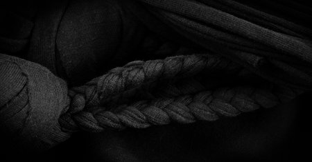 Texture, background, pattern. Fabric in black braids. Knitted knitted background with embossed pattern. Braids in knitting.の写真素材