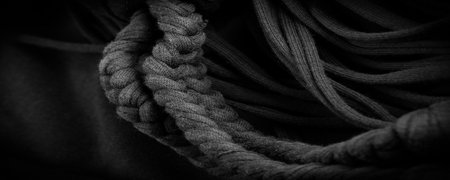 Texture, background, pattern. Fabric in black braids. Knitted knitted background with embossed pattern. Braids in knitting.の写真素材