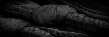 Texture, background, pattern. Fabric in black braids. Knitted knitted background with embossed pattern. Braids in knitting.の写真素材