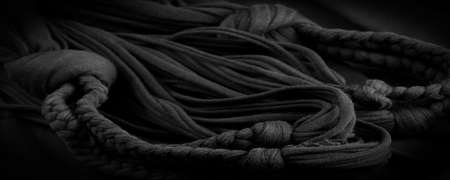 Texture, background, pattern. Fabric in black braids. Knitted knitted background with embossed pattern. Braids in knitting.の写真素材