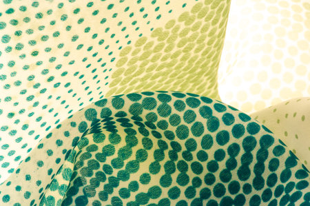 silk fabric. texture or background with cool mint, blue and yellow green polka dot dots on a beige...