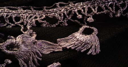 Dark brown woolen scarf. with a sewn-on lace on a strip. Texture. Background. Templateの写真素材