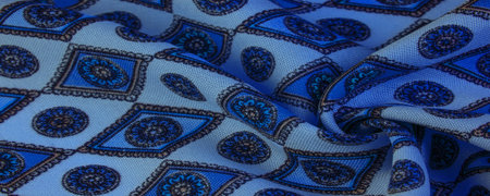 silk fabric in soft blue with a print of rhombuses, squares and medals. Tell a story and make a...