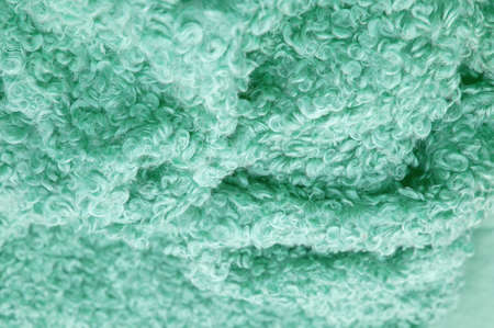 Karakul artificial ram skin. Green color. Incredibly high-quality artificial eco-fur under a young astrakhan (lamb) fabrics haute couture, Coat fabrics, texture, background, patternの写真素材