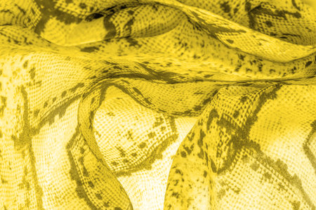 yellow fabric with a pattern of squares, background texture of bright yellow fabric close-up....