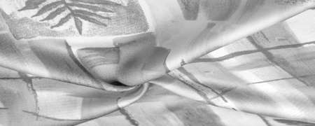 Black and white fabric with an abstract pattern, a print of branches with leaves of flora. Background texture. Background. Template.の写真素材