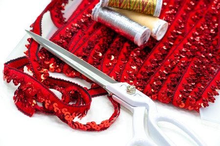 Red sequins. Ribbon for fabric decoration. Background texture, sunrise. Smooth slope of rows of...