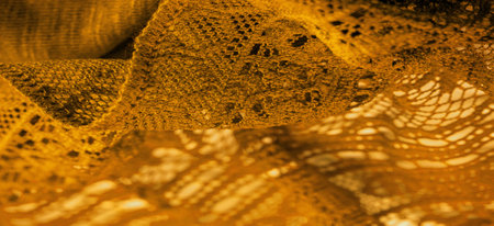 Yellow lace fabric, a thin open fabric, usually of cotton or silk, made using loops, twisting or knitting threads into patterns. Background texture, pattern.の写真素材