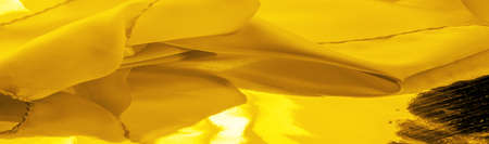 yellow silk fabric, beautiful smooth elegant wavy yellow satin silk luxury fabric, abstract design. background texture, patternの写真素材