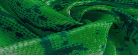green fabric with snakeskin pattern, background texture of bright green fabric close up. background, texture, patternの写真素材