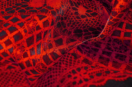 Texture, background, pattern. Ruby red lace fabric, a combination of red with black fabric....