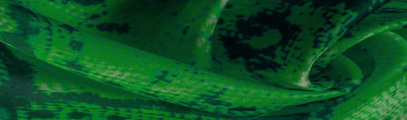 green fabric with snakeskin pattern, background texture of bright green fabric close up. background,...