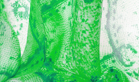 green fabric with snakeskin pattern, background texture of bright green fabric close up. background,...