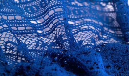 Background, texture, pattern, blue lace fabric, thin open fabric, usually made of cotton or silk, made using loops, twisting or knitting threads in patternsの写真素材