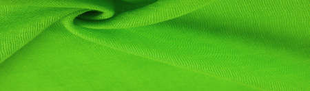 Green silk fabric. Grunge surface texture with fine grains, green satin texture, which is an emerald fabric, silk panorama, with a beautiful soft natural blur pattern.の写真素材