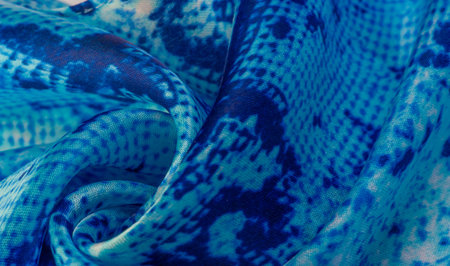 blue fabric with snakeskin pattern, background texture of bright blue fabric close up. background,...