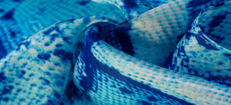 blue fabric with snakeskin pattern, background texture of bright blue fabric close up. background,...