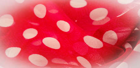 Background texture, decorative ornament, red polka dot fabric in white polka dots, round dots on fabric, shaped like or approximately like a circle or cylinder.の写真素材
