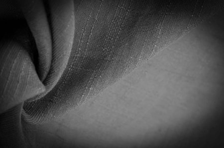 black fabric, deep black silk, woven fabric texture background. Decorative items close-up. Wallpaper...