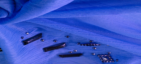 Background design texture, silk pattern, blue fabric with glued decorative faceted stonesの写真素材