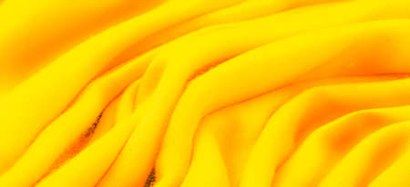 Texture, background, design, yellow gold fabric, twill. Thin fabric with diagonal weaving of threads. From Latin and French, the name of the material is translated as âsilkâ.の写真素材