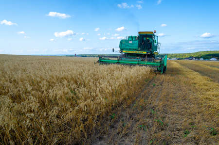A summer photo of harvesting barley, the Harvester is a machine used to harvest cereals such as wheat, rye, barley, oats, corn, flax and soy. 2019 09 06 Tukaevsky District Tatarstan Russiaのeditorial素材