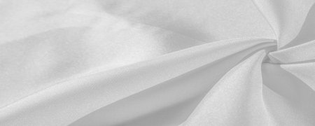Silk is white. White gray satin texture, it is silver fabric, silk panorama, background with...