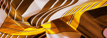 Texture, background, silk fabric with a yellow striped pattern. The design of this fabric is dedicated to a white rabbit mosaic representing the look of a fabulous vest.の写真素材
