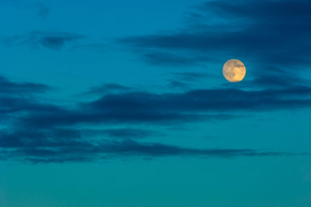 Night photo. The moon in the sky with clouds is colored by the sun. moonlight, moonshine, shine