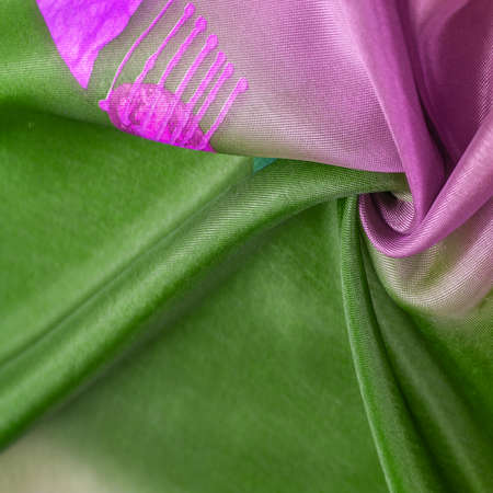 Background texture, silk fabric, shiny red green, with a small abstract print of rock paintingsの写真素材