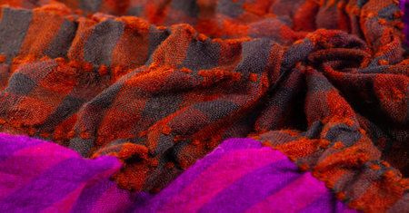 Texture, background, pattern. A woolen scarf to be worn around a person's neck. Brown red black...