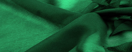 Texture. Background. Green silk fabric, view from above. Smooth elegant green silk or satin luxury cloth texture can use as abstract background with copy space.の写真素材
