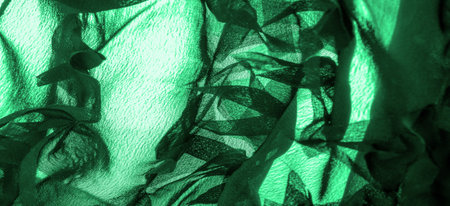 Texture. Background. Green silk fabric, view from above. Smooth elegant green silk or satin luxury...