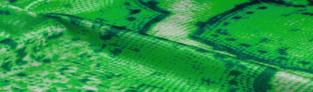 green fabric with snakeskin pattern, background texture of bright green fabric close up. background, texture, patternの写真素材