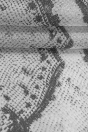 gray monochrome fabric with snakeskin pattern, background texture of bright gray fabric close up....