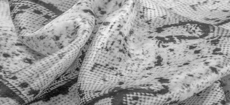 gray monochrome fabric with snakeskin pattern, background texture of bright gray fabric close up....