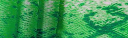 green fabric with snakeskin pattern, background texture of bright green fabric close up. background,...